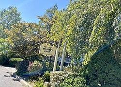 A sign marking the entrance into the village at the Munsey Park-Flower Hill Border, on Manhasset Woods Road.