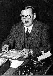 Upper body of a bespectacled Anton Drexler sitting at a desk