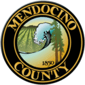 The county's official seal, in chief two redwood trees and the numbers '1850', a breaking wave on the Pacific Ocean and a vineyard set in relief, bordered by a dark brown circle with the words 'Mendocino County' appearing within the border in gold block letters