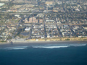 Aerial view of part of old town Encinitas showing Moonlight Beach on the left. Parallel with the shore is Historic Coast Highway 101; also parallel and further inland is Interstate 5.