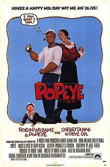 Popeye standing back to back with Olive, swee'pea crawls at his feet.