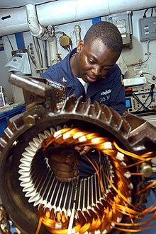 US Navy 040902-N-7683J-003 Electrician's Mate 3rd Class Tayo Gbadebo from Lagos, Nigeria, rewires the motor from an Aqueous Film Forming Foam (AFFF) Sprinkler System's pump.jpg