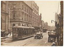 (Looking north along George Street (with tram, T-model Ford and hansom cab) from Union Line Building (incorporating the Bjelke-Petersen School of Physical culture), corner Jamieson Street), n.d. by (5955844045).jpg