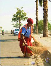 Woman sweeping the road