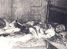 Kelly's eviscerated body lying on a bed. Her face is mutilated.