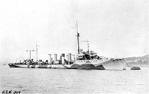 USS Cassin (DD-43) moored alongside another U.S. Navy destroyer, at Queenstown, Ireland, circa 1918. She is painted in "Dazzle" type camouflage.