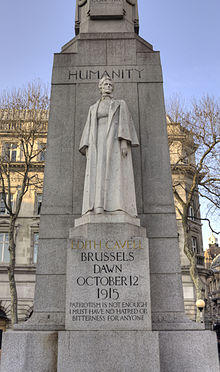 A marble statue of Edith Cavell in nurse's uniform backed by a large granite column