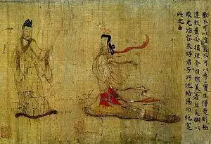A woman walking towards a man who has raised his hand towards her and is turning away