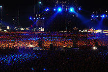 Darkened stadium concert, with blue lights