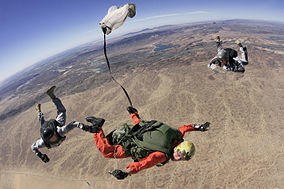 A Special Forces high altitude-low opening student pulls his rip cord while two instructors observe and critic his jump at Yuma Proving Grounds Ariz.jpg