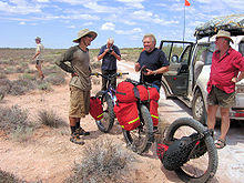 Photograph of Jakub Postrzygacz with his special fatbike on the Canning Stock Route near Lake Disappointment