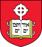 Coat of arms of the school, containing a book device inscribed with Hebrew letters and cross in front of a red background