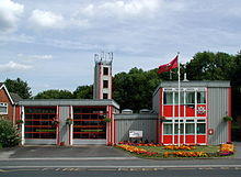 A grey and red, very angular and clean looking prefabricated building of two bays.